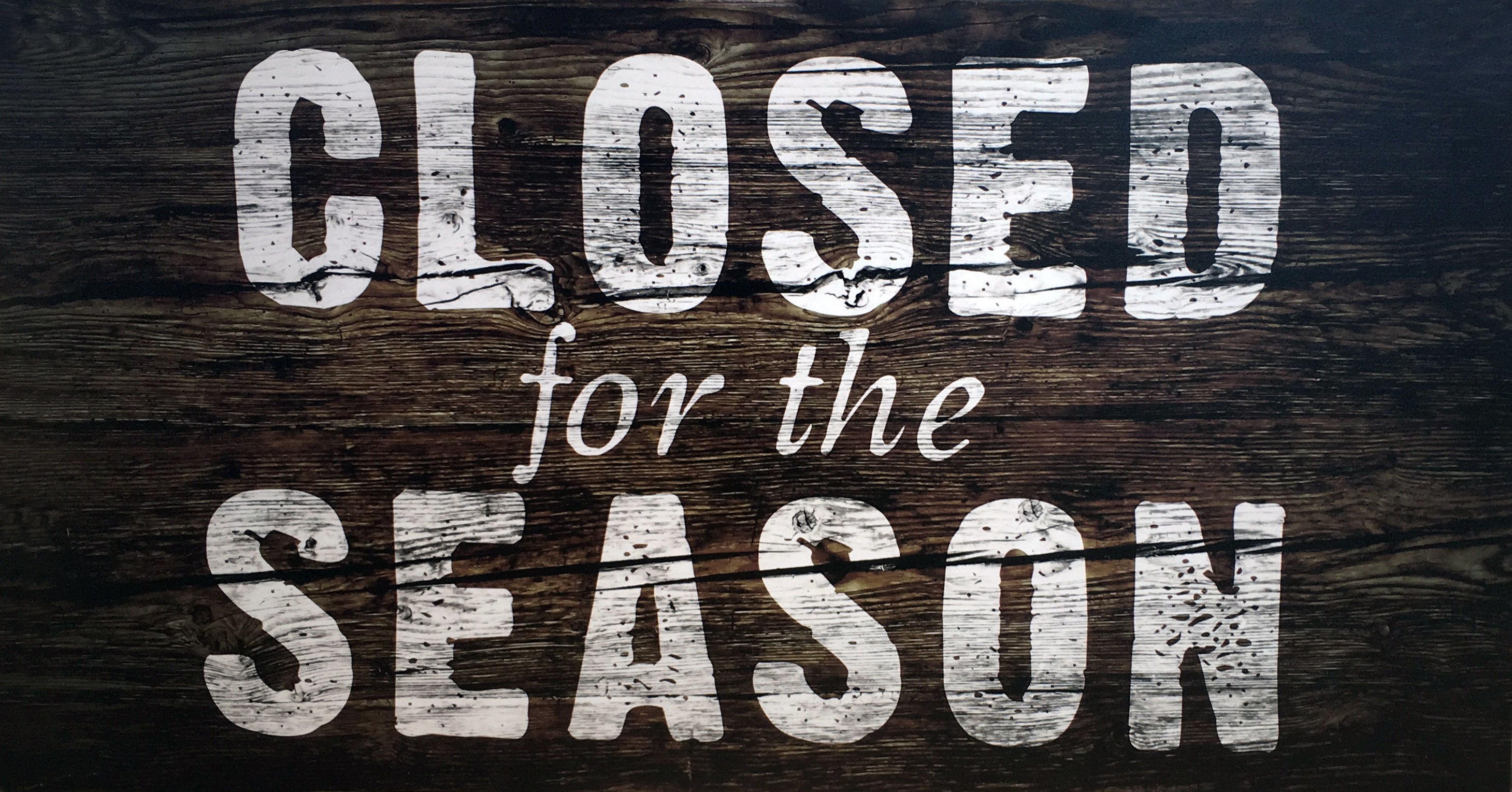 'Closed for the Season' is written in white paint against a wooden sign.