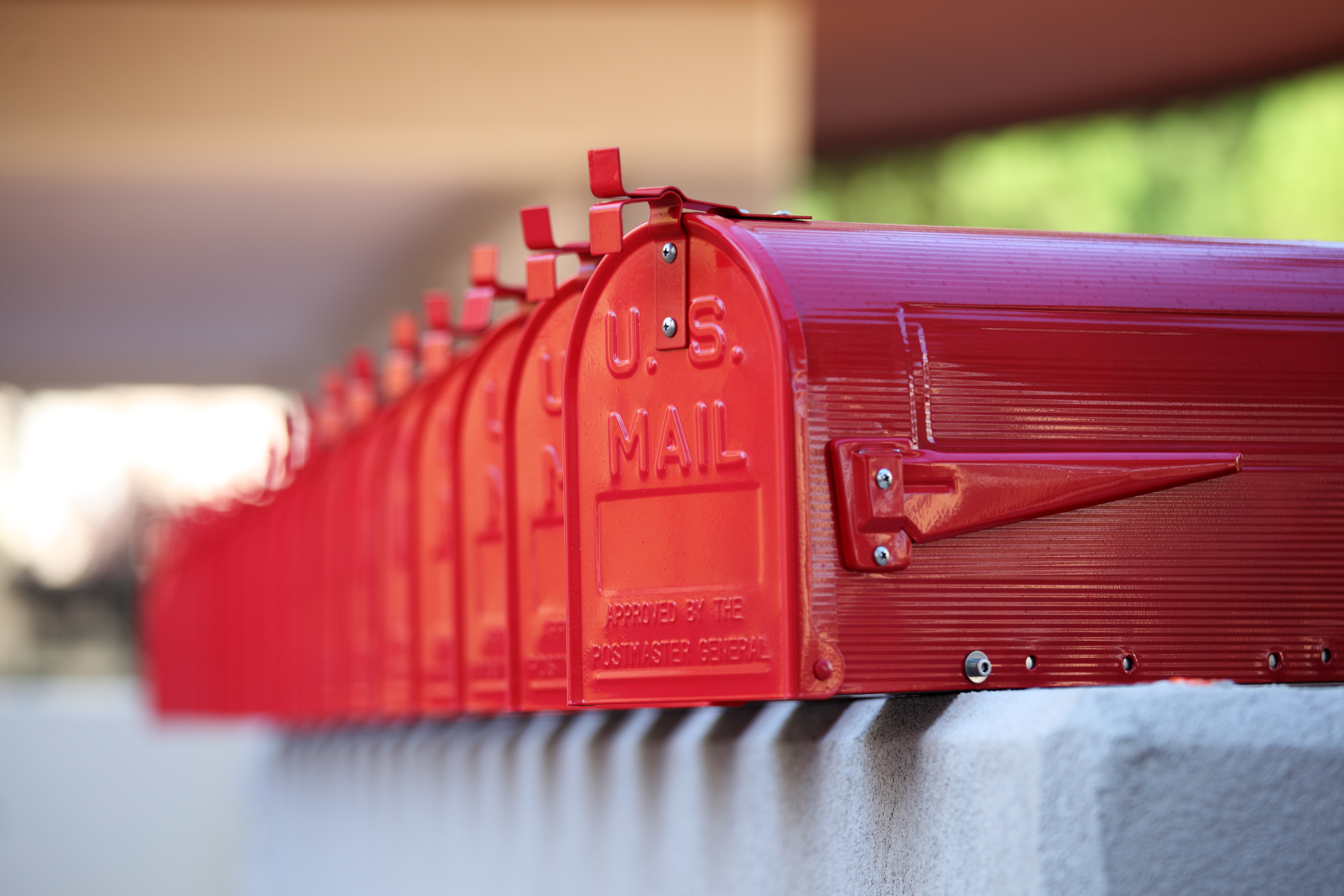 A long row of shiny red mail boxes with U.S. Mail written on the front of them.
