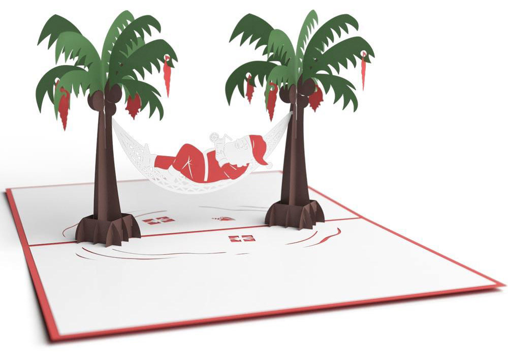 An open, three-dimensional greeting card showing a Christmas scene with Santa laying in a hammock from two palm trees.