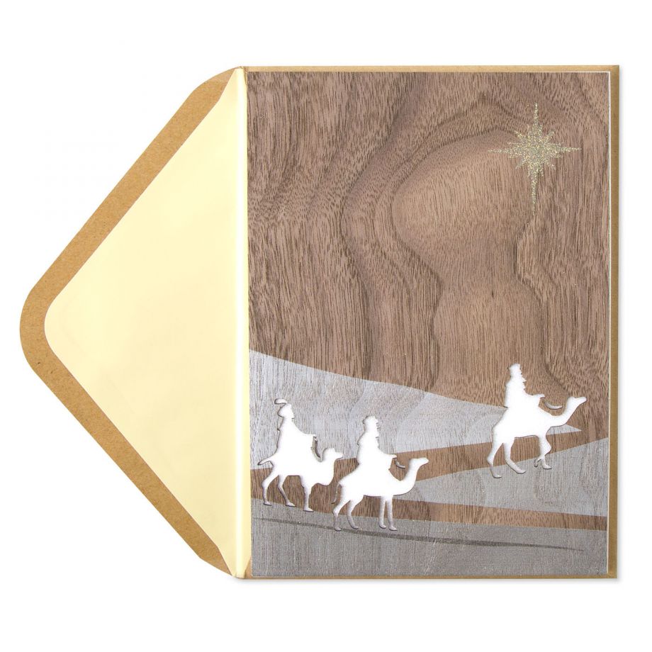 This wood-grain greeting card features the three wise men traveling through the desert with the North Star gleaming above. 