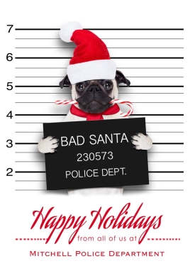 A pug, wearing a Santa cap and chewing on a candy-cane, is receiving a mugshot. The text below him reads 'Happy Holidays' in red letters.