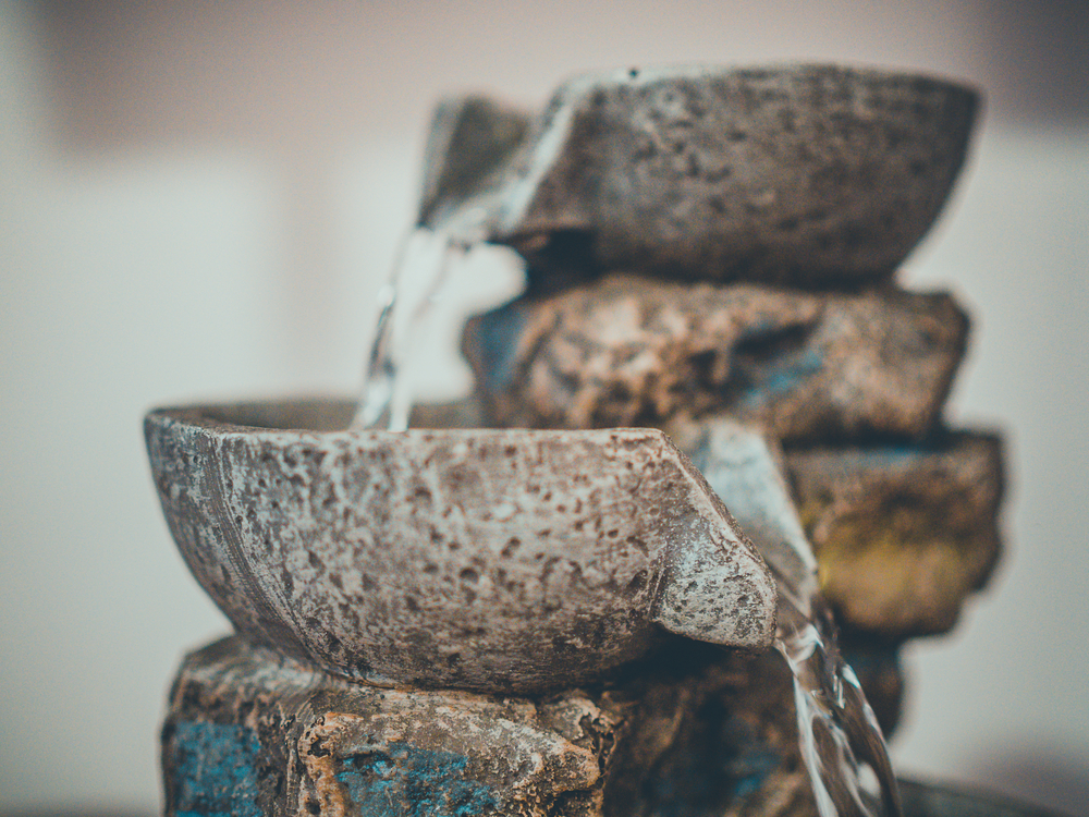 Water runs down the rocks of an indoor fountain.