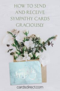 Light colored floral arrangement with a blue marble sympathy card and a message in green that reads, How to Send and Receive Sympathy Cards Graciously.