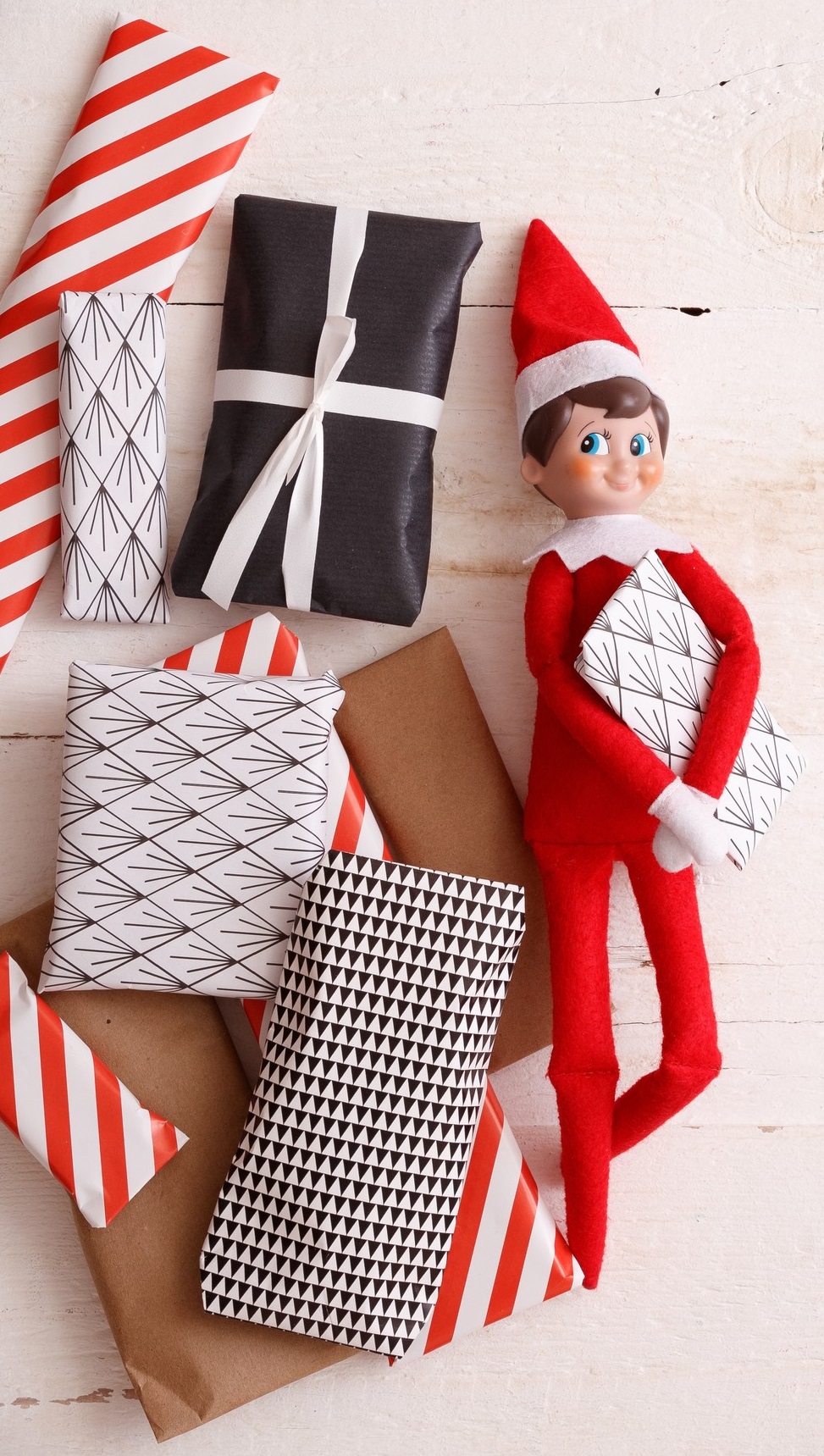 Closeup of Elf with advent presents on white wooden background. Christmas and Holiday concept