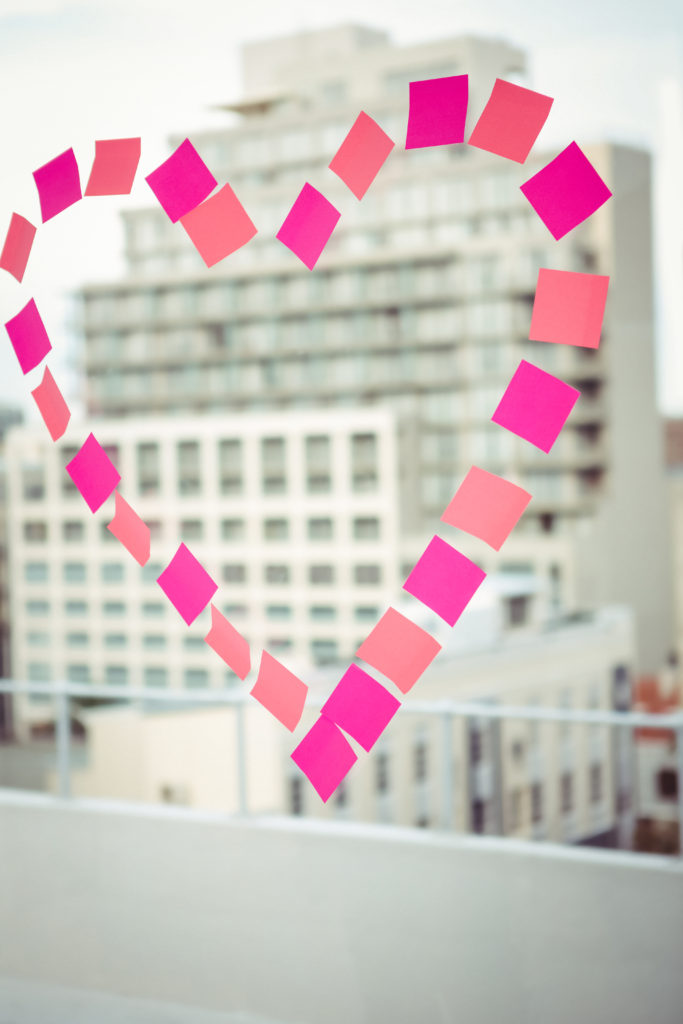 Heart in post-it on a window in office