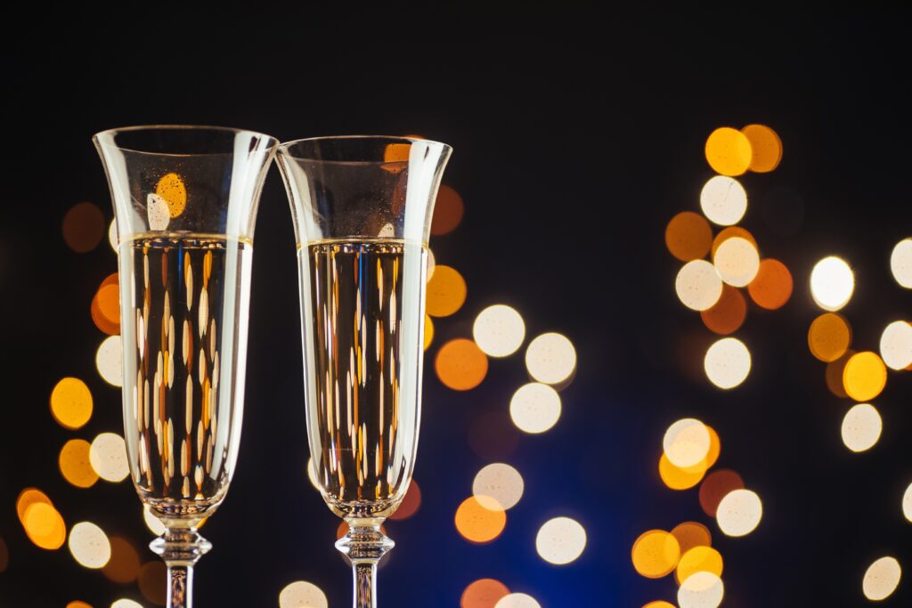 Champagne for festive occasions against a dark background with gold shimmering light and bokeh