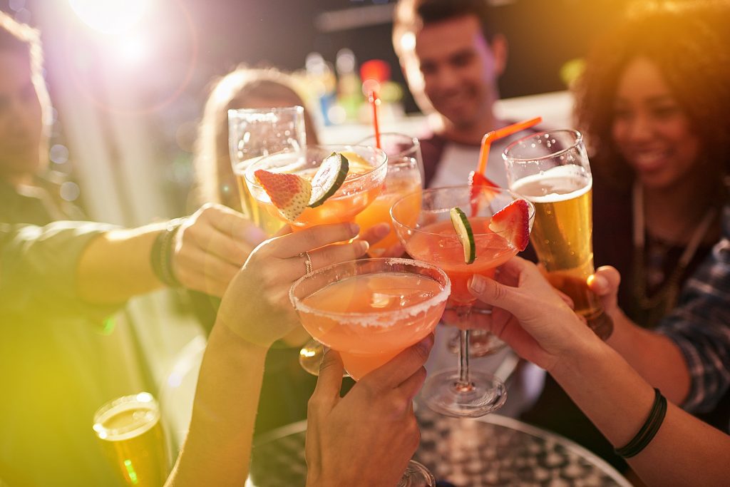Shot of a group of people toasting with their drinks at a nightclub