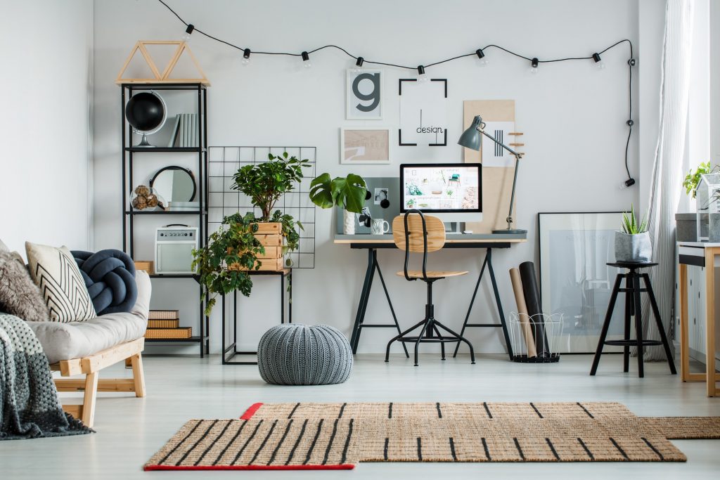 Designed carpet and grey pouf on glossy white floor. Home office design concept