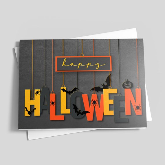 Spiders and bats building a Happy Halloween sign in yellow and orange on the front of a greeting card from CardsDirect.